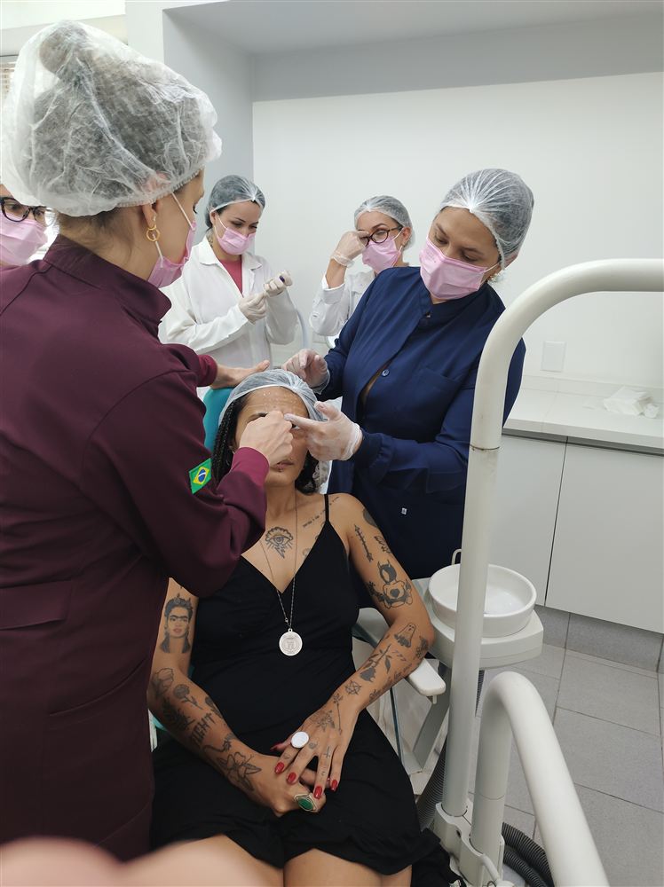Turma acompanhando de perto a marcação de pontos de aplicação em paciente modelo